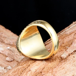 Vintage men's titanium gold ring with relief patterns on rustic wood background