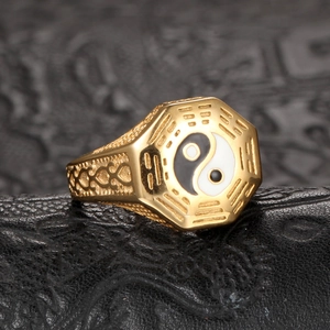 Polished gold Tai Chi Bagua ring with Taoist octagon pattern on black leather background