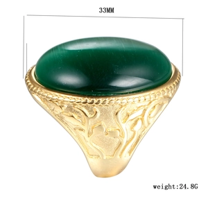 Detailed view of heavy titanium steel ring with green cat eye stone and vine carvings