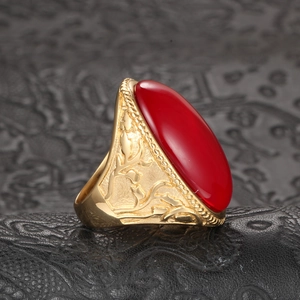 Macro shot of gold vintage ring featuring large red oval stone and branch texture