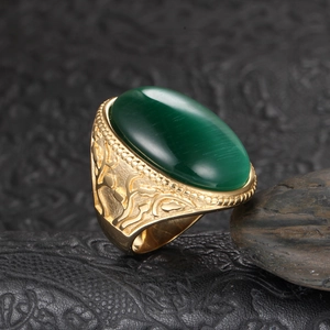 Macro detail of vintage gold titanium ring with a large green oval cat eye gemstone