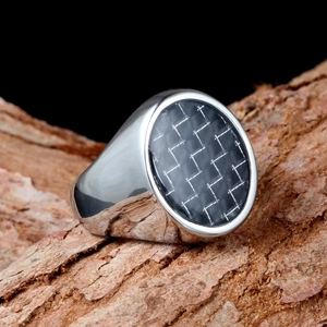 Vintage carbon fiber signet ring in silver stainless steel on wooden background