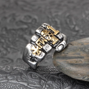 Macro shot of gothic skull ring with gold embossed crosses and bold lettering detail
