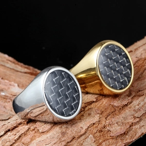 Polished gold and silver carbon fiber inlay signet rings on a natural wood base