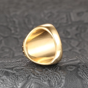 Vue macro d'une bague large plaquée or avec texture à paliers sur cuir noir