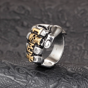 Detail of silver fist ring with skull relief and gothic letters on knuckles