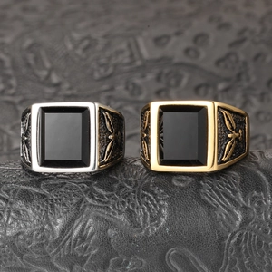 Macro detail of men's vintage gold ring with square black onyx and relief eagle pattern