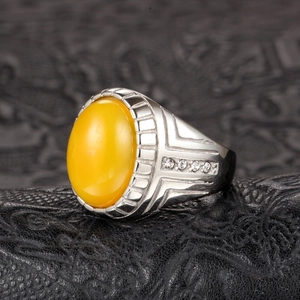 Detalle macro de anillo de plata vintage con ágata amarilla ovalada y diamantes laterales