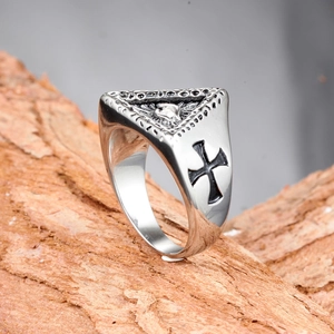 Detalle de anillo vintage de titanio plateado con ojo que todo lo ve y patrón cruz