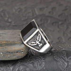 Macro view of men's stainless steel ring with black onyx stone and eagle relief details