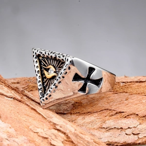 Detalle del anillo gótico con ojo y relieve de cruz sobre fondo de corteza rústica