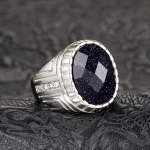 Detalle macro de anillo de piedra arenisca azul con grabados laterales y circonitas