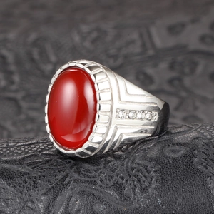 Macro de un anillo vintage de plata para hombre con ágata roja ovalada y diamantes laterales