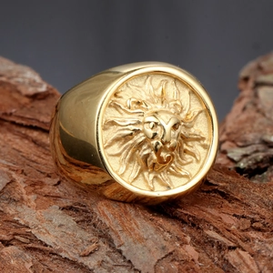 Vintage golden stainless steel lion head signet ring displayed on a natural wood bark background