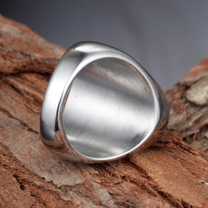 Polished silver stainless steel men's ring in signet style on natural wood bark