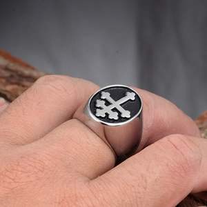 Macro view of men's stainless steel signet ring with black enamel and Lorraine cross detail