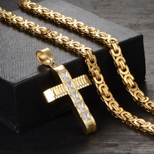 Detailed macro of gold plated cross pendant with crystal inlay on black jewelry box