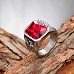 Detail shot of men's titanium ring with square red gemstone and engraved cross patterns