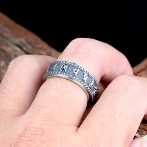 Gros plan sur une bague rotative vintage en acier avec des symboles sanskrits