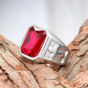 Detailed close-up of a men's silver ring with a red square gemstone and cross engraving