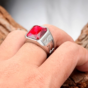 Macro detail of men's titanium ring with rectangle red gemstone and cross relief