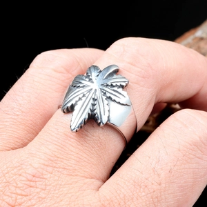 Macro-opname van een punk-stijl roestvrijstalen ring met bladontwerp gedragen aan de vinger