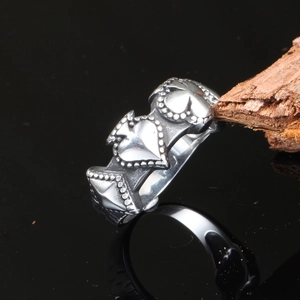 Macro shot of punk style stainless steel heart ring with textured beaded edge and relief