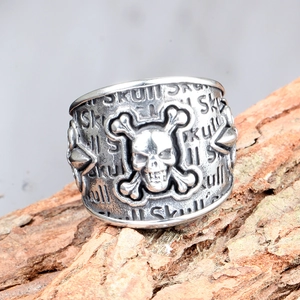 Macro view of vintage silver skull and crossbones ring with engraved SKULL pattern