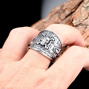 Macro shot of a punk skull ring with embossed SKULL lettering on a rugged bark background