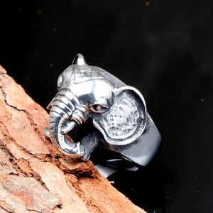 Macro shot of retro elephant head ring with detailed oxidized finish on wood bark
