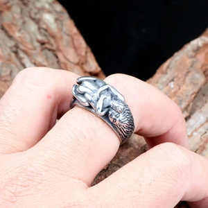 Détail d'une bague vintage en acier inoxydable avec gravures de personnages gothiques