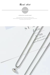 Detail of magnetic astronaut pendants with interlocking silver chain links for couples