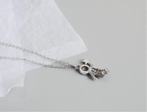 Detailed macro shot of vintage silver astronaut pendant holding a star on a link chain