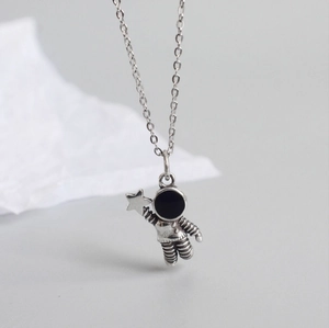 Detailed view of astronaut pendant holding a star with black enamel mask on silver chain