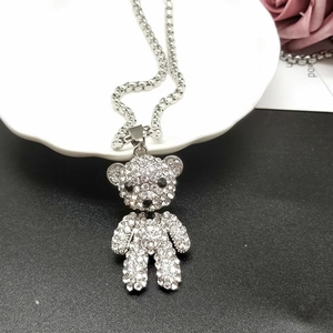 Vue détaillée du pendentif ourson étincelant avec strass sur une chaîne en métal argenté