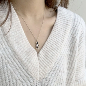 Minimalist astronaut pendant necklace in S925 silver on a white knitted sweater