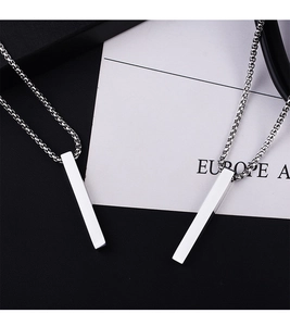 Macro view of twin silver geometric pendant necklaces with polished box chains