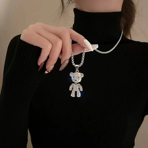 Collier ours en peluche étincelant avec pavé de cristaux sur chaîne argentée sur pull