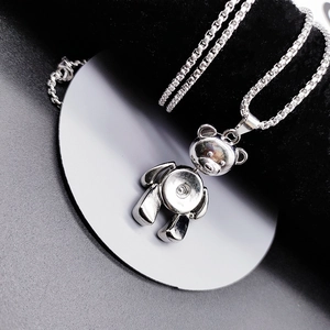 Macro shot of polished stainless steel teddy bear pendant with unique snap button design