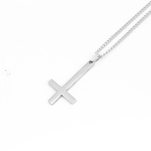 Gros plan du pendentif croix inversée argentée polie avec sa fine chaîne à maillons