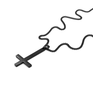 Vue macro du pendentif croix inversée noir mat avec une finition en acier inoxydable