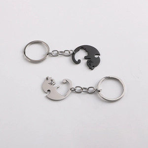 Close-up of interlocking black and silver heart-shaped cat pendants for couple keychains