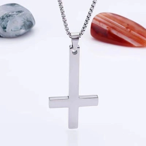 Pendentif croix inversée en argent poli avec chaîne vénitienne sur fond pierre