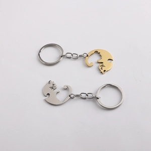 Detailed view of couple's heart-shaped cat puzzle keychains in gold and silver finish