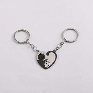 Matching heart-shaped cat puzzle keychains in polished black and silver stainless steel