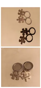 Detail view of puzzle piece keychains in silver and black with Better Together engraving