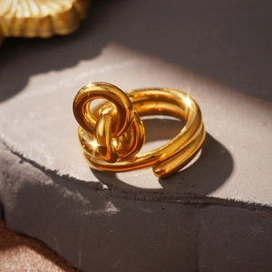 Macro shot of gold knotted double-layer wrap ring on a natural stone background