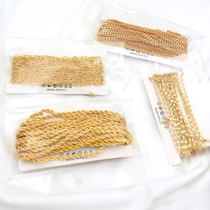 Detailed macro view of four styles of 18K gold plated DIY chains in retail packaging