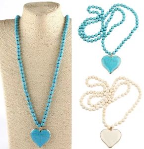Detail of turquoise and white marble heart pendants with gold trim on beaded necklaces