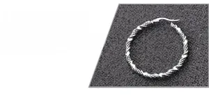 Vue détaillée d'une créole argentée avec texture corde torsadée et finition polie